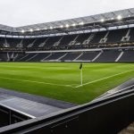 Club Licensing Super League: Mengapa Stadion Bisa Berujung Pengurangan Poin? Stadion sepak bola profesional dengan lapangan dan tribun kosong sebagai gambaran pentingnya infrastruktur dalam lisensi klub