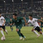 Pertandingan sepak bola di stadion Indonesia yang menggambarkan persaingan Pegadaian Championship