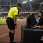 Wasit sepak bola berdiskusi dengan perangkat VAR di stadion menjelang pertandingan