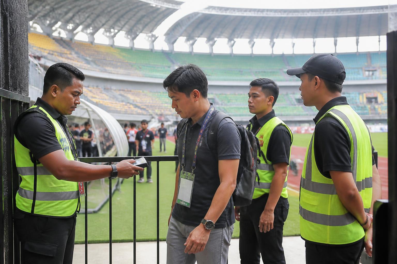 Match steward memeriksa akses personel di pintu area terbatas stadion sepak bola