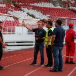 Petugas operasional berkoordinasi di area stadion sepak bola sebelum pertandingan
