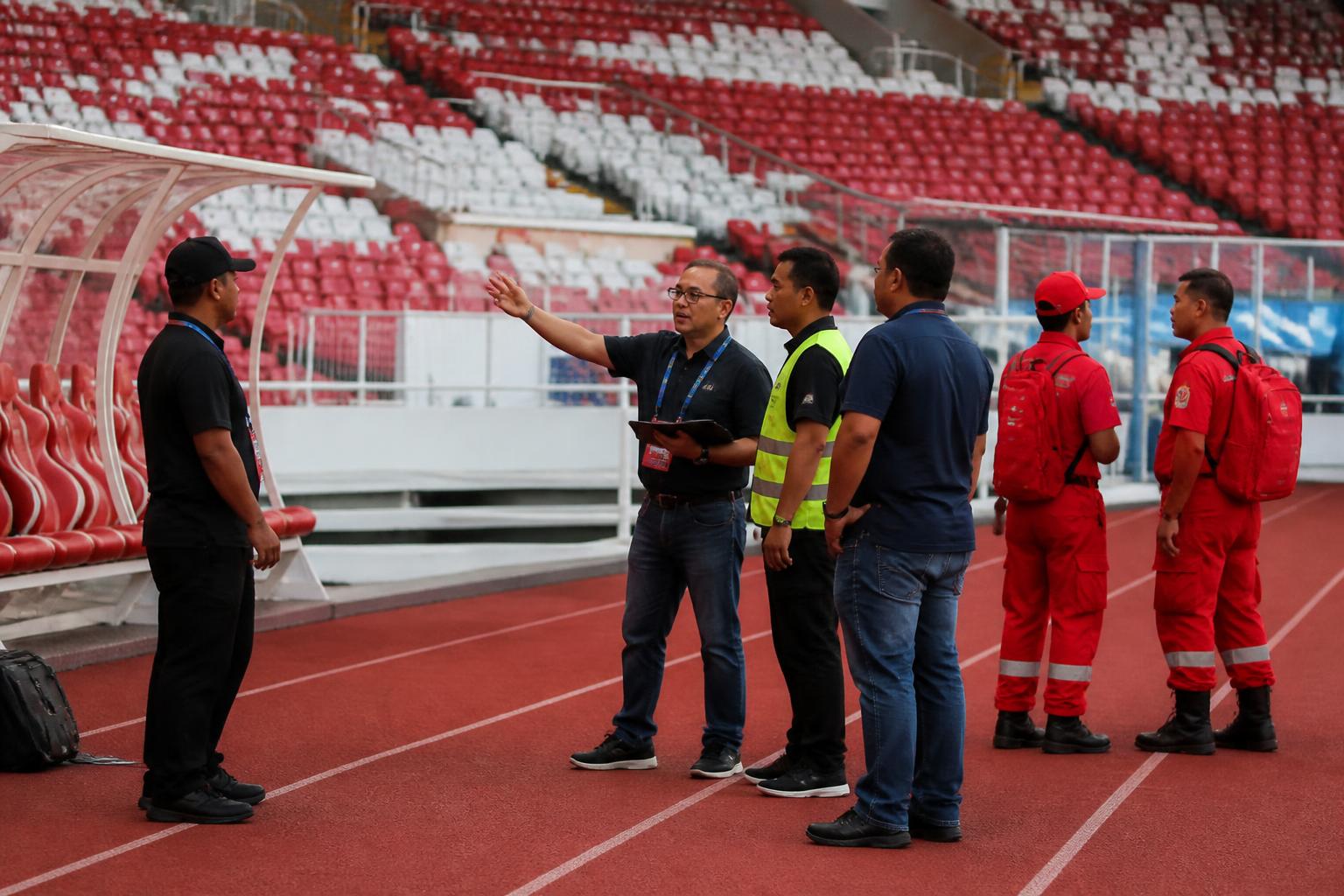 Petugas operasional berkoordinasi di area stadion sepak bola sebelum pertandingan
