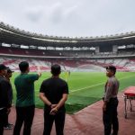 Petugas menyiapkan stadion sepak bola untuk pertandingan profesional dengan tim keamanan dan medis di area lapangan