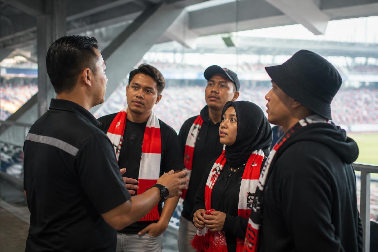 Petugas penghubung klub berbicara dengan kelompok suporter di area stadion